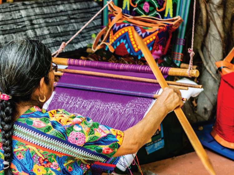 A woman weaving a rug in Port Santo Tomas de Castilla Guatemala