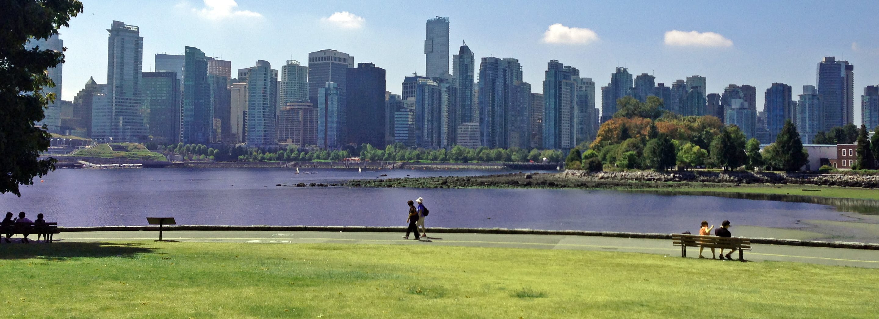 View of a couple walking near the Vancouver, BC skyline while on one of Holland America’s Alaska shore excursions