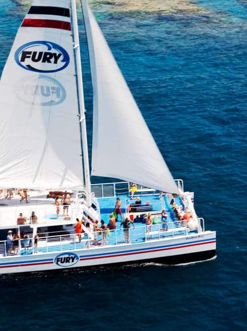 People enjoying a catamaran sail and snorkel adventure on a cruise excursion