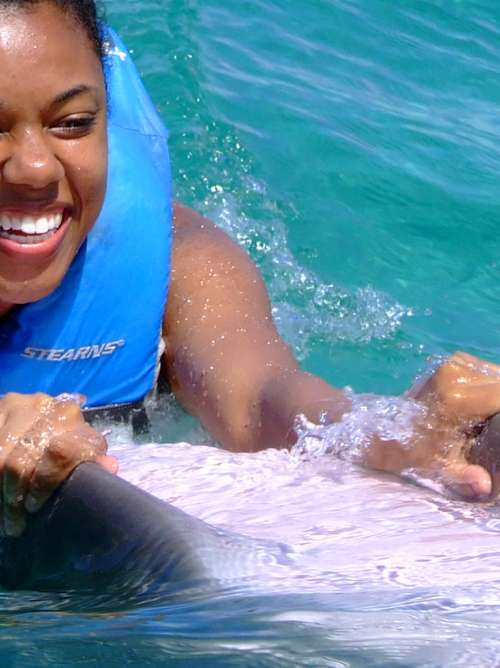 Woman swimming with a bottlenose dolphin in Jamaica