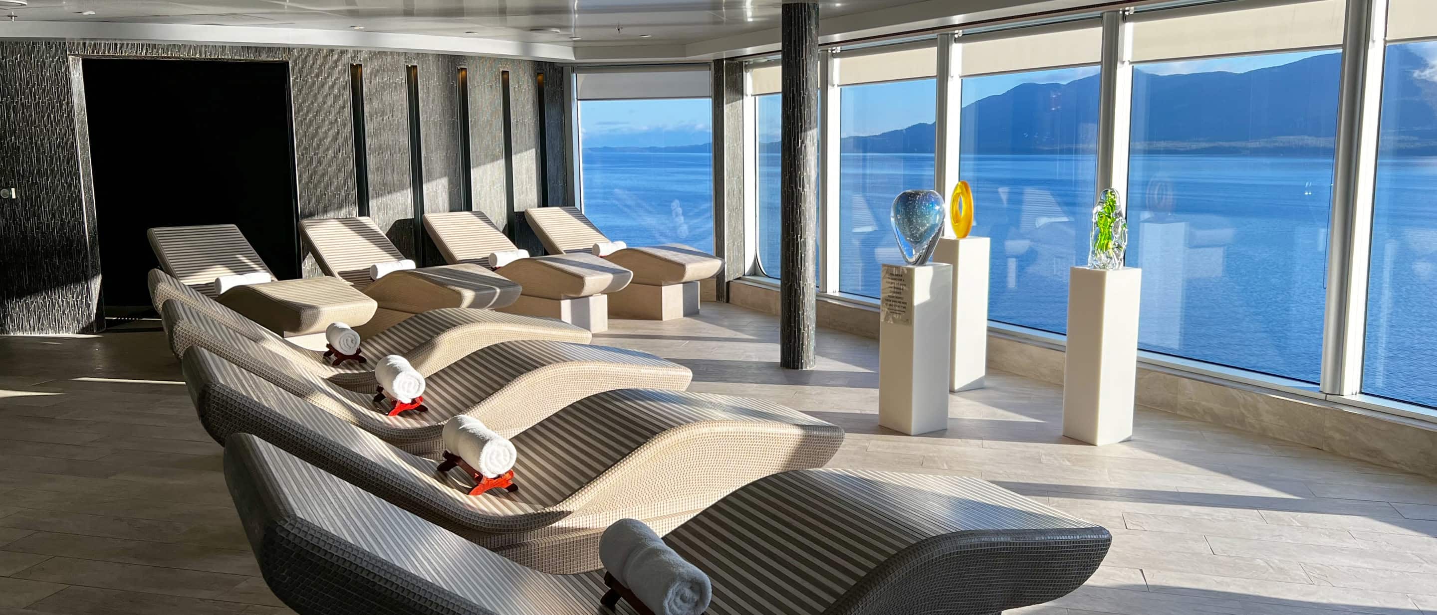 Ocean-view loungers and tranquil ambiance at Greenhouse Spa & Salon aboard a Holland America cruise ship.
