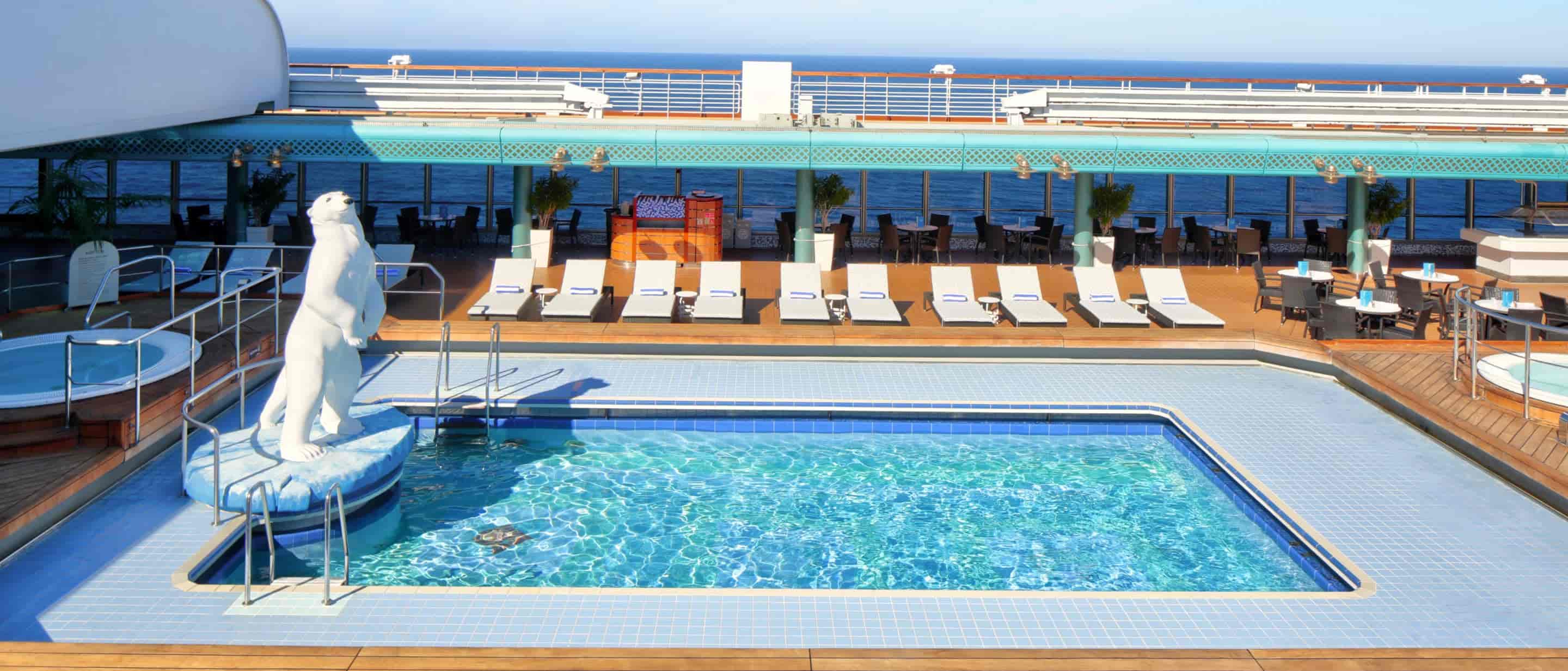 Lido Pool area with swimming pool, polar bear statue, lounge chairs, and ocean view aboard a Holland America cruise ship.
