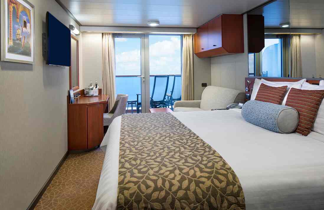 Aft View Verandah stateroom with queen bed, sofa, desk, wall-mounted TV, and balcony on a Holland America cruise ship.