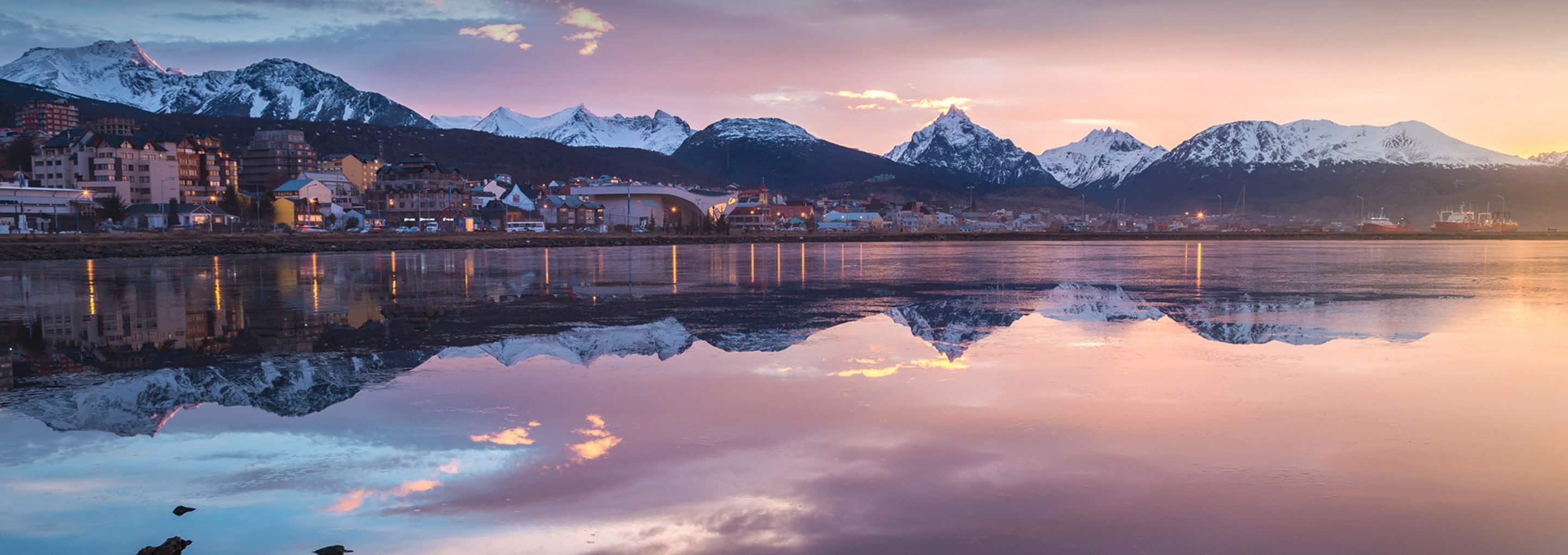 Snow capped mountains behind an oceanside town in South America opens a dialog