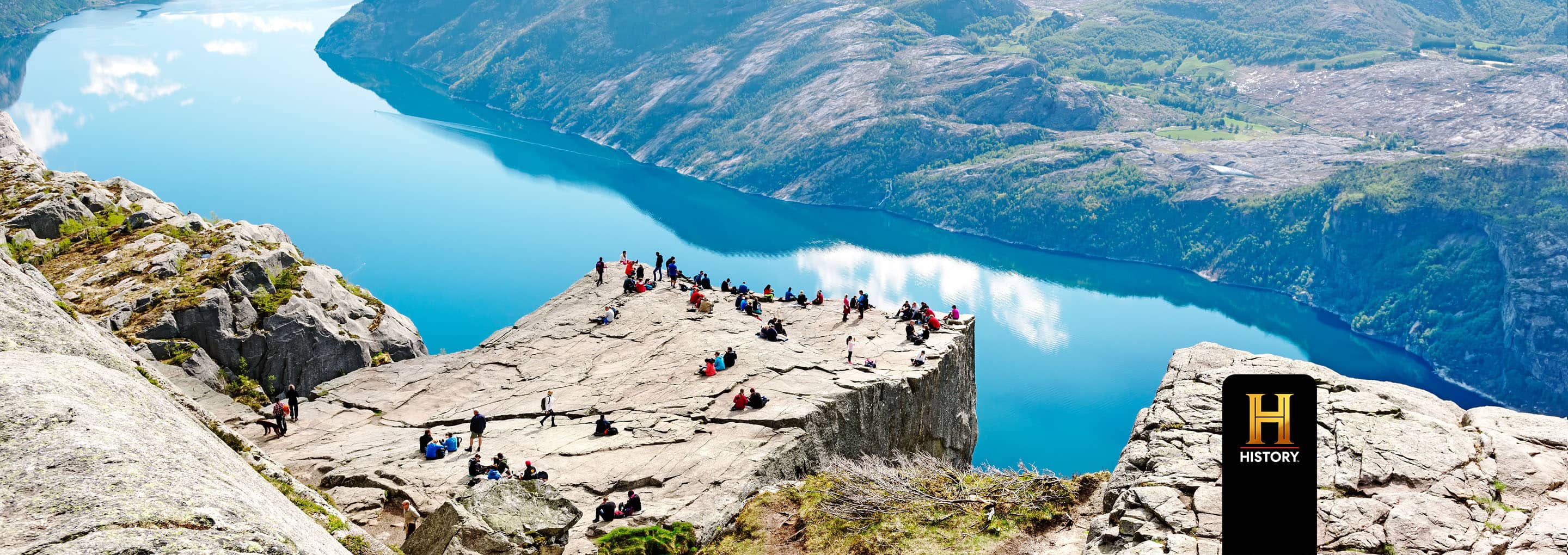 Preikestolen, also known as Pulpit Rock, in Norway with people enjoying the panoramic view of the fjord and mountains. opens a dialog