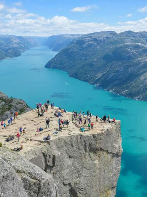 tourists look at the vista from pulpit rock in norway
