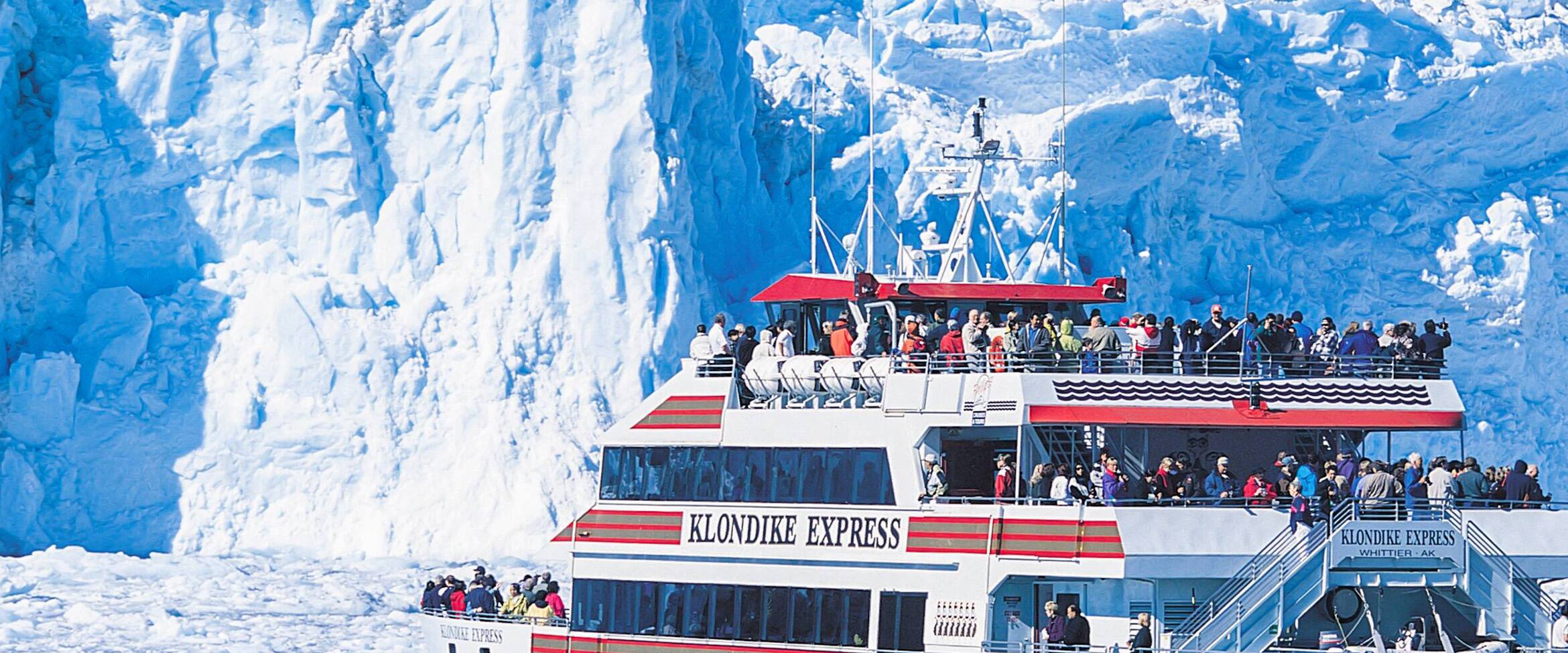 view of a Klondike Express catamaran cruising near a glacier in Alaska