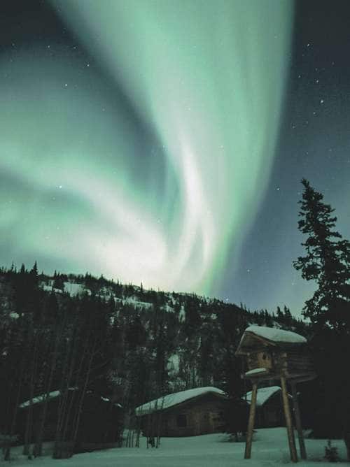 Aurora Borealis Northern Lights over cabins in Alaska