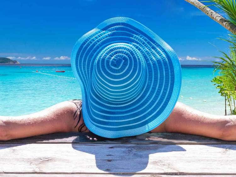 woman in sun hat relaxing on Caribbean beach