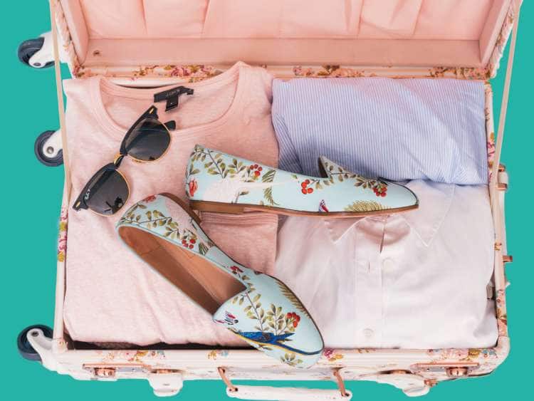 open suitcase packed with vacation clothes
