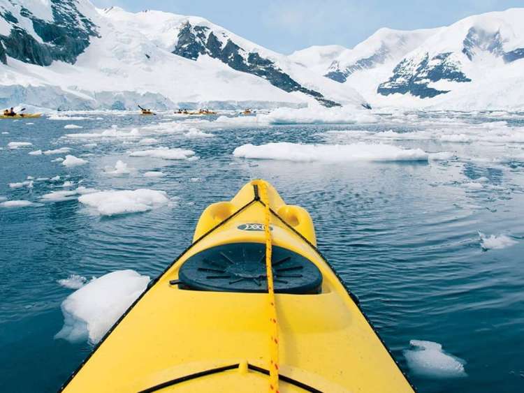 Kayakers in Neko Harbour, Antarctica, a region visited on a luxury, all-inclusive Seabourn cruise ship.