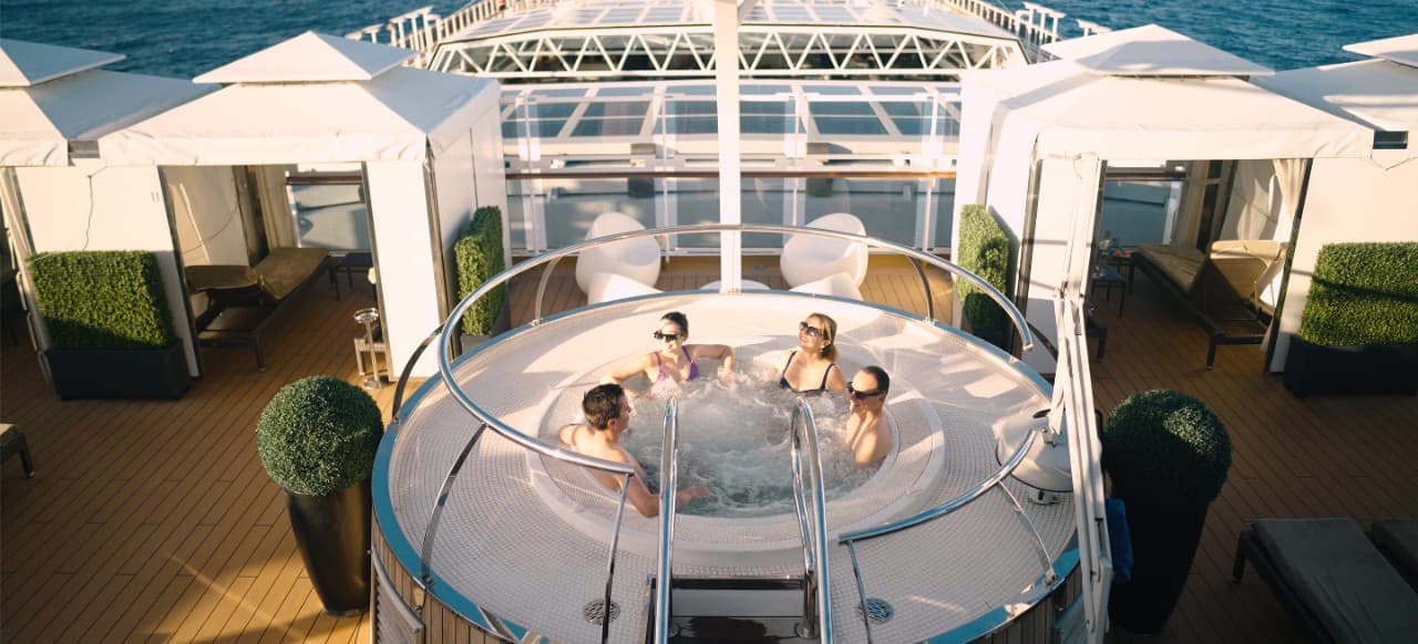 A group of cruise guests relaxing in a hot tub in The Retreat.