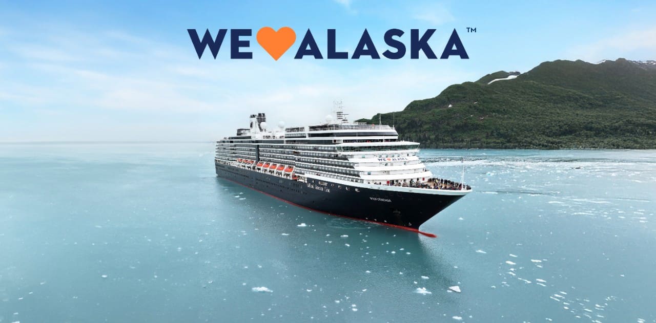 Holland America cruise ship sailing through icy waters in Alaska with scenic mountain backdrop.