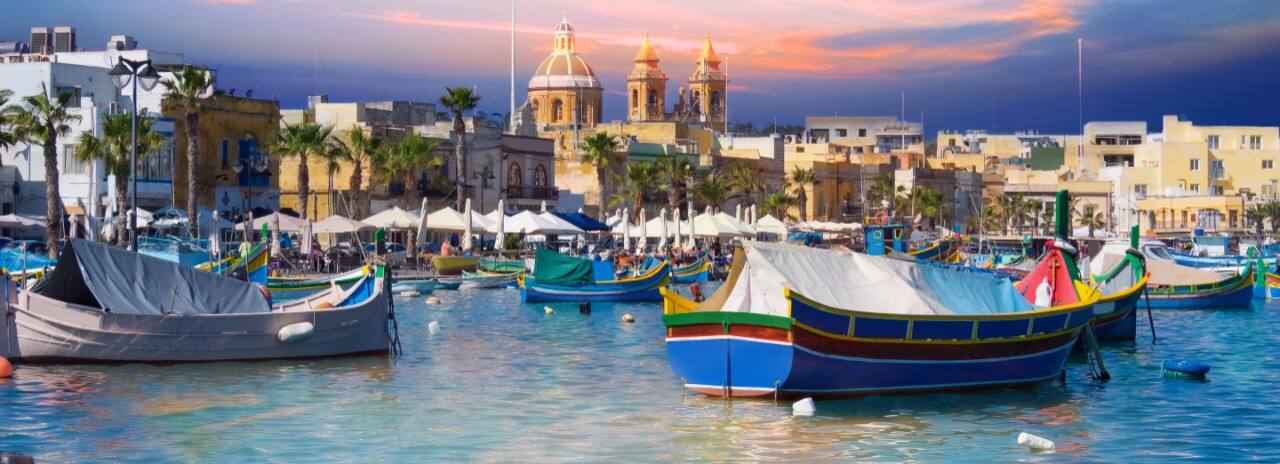 Many boats in the water in the Grand Harbor in Malta with the city in the background