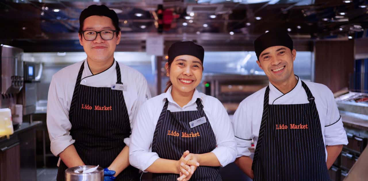 3 Lido Market employees standing in the kitchen and smiling.
