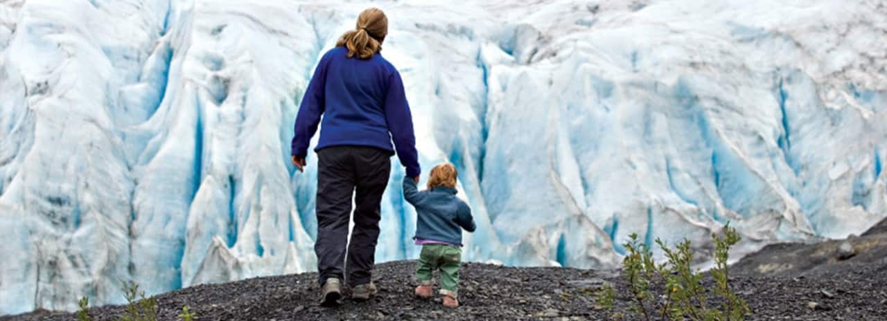A woman and child explore near an Alaskan glacier on a Holland America Line Alaska shore excursion 