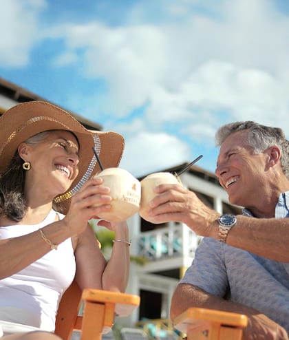 Couple Cheers their drinks in cups made out of a coconut