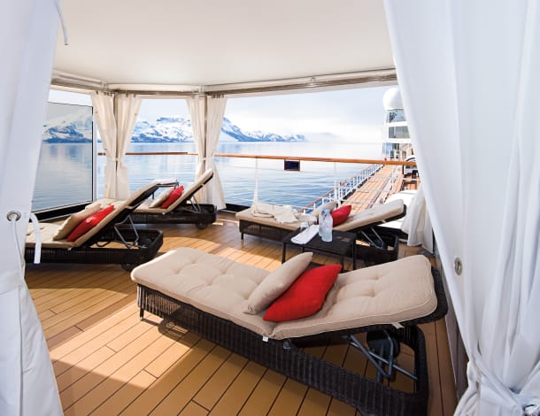 Private cabanas on Holland America Line Eurodam's The Retreat, with ocean and Alaskan mountain views.