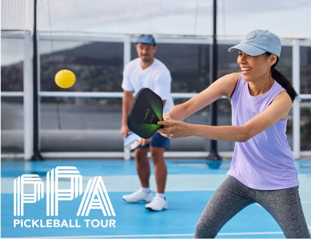 A pair of pickleball players play on a pickleball court aboard a Holland America cruise ship