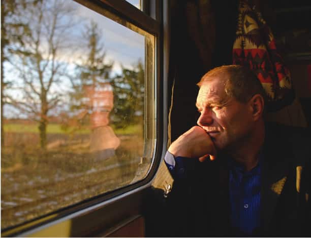 A passenger looks out the window of his train car
