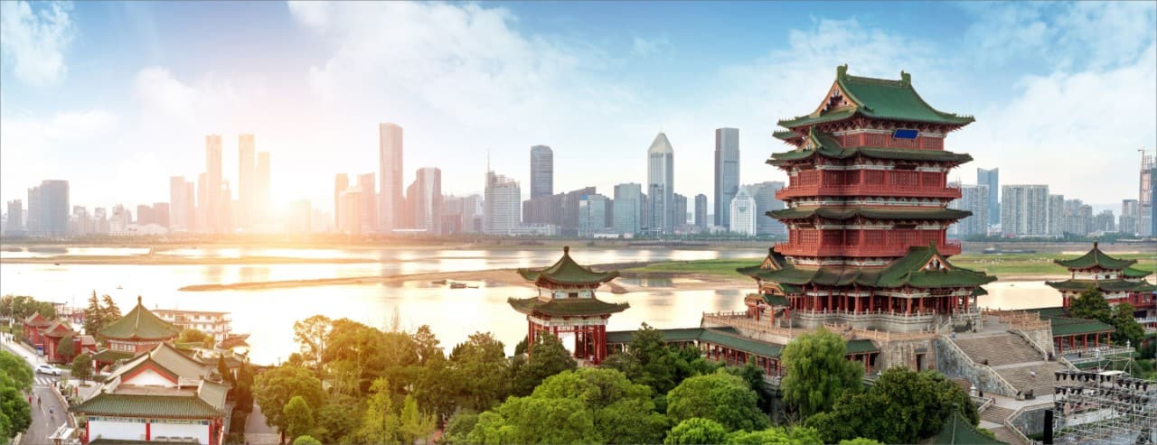 Tengwang Pavilion in Nanchang with a modern skyline across the Gan River.