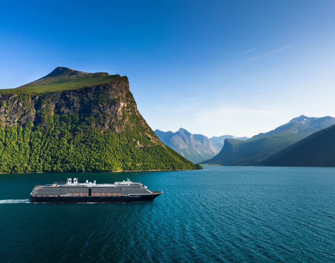Holland America cruise ship sailing through a Norwegian fjord