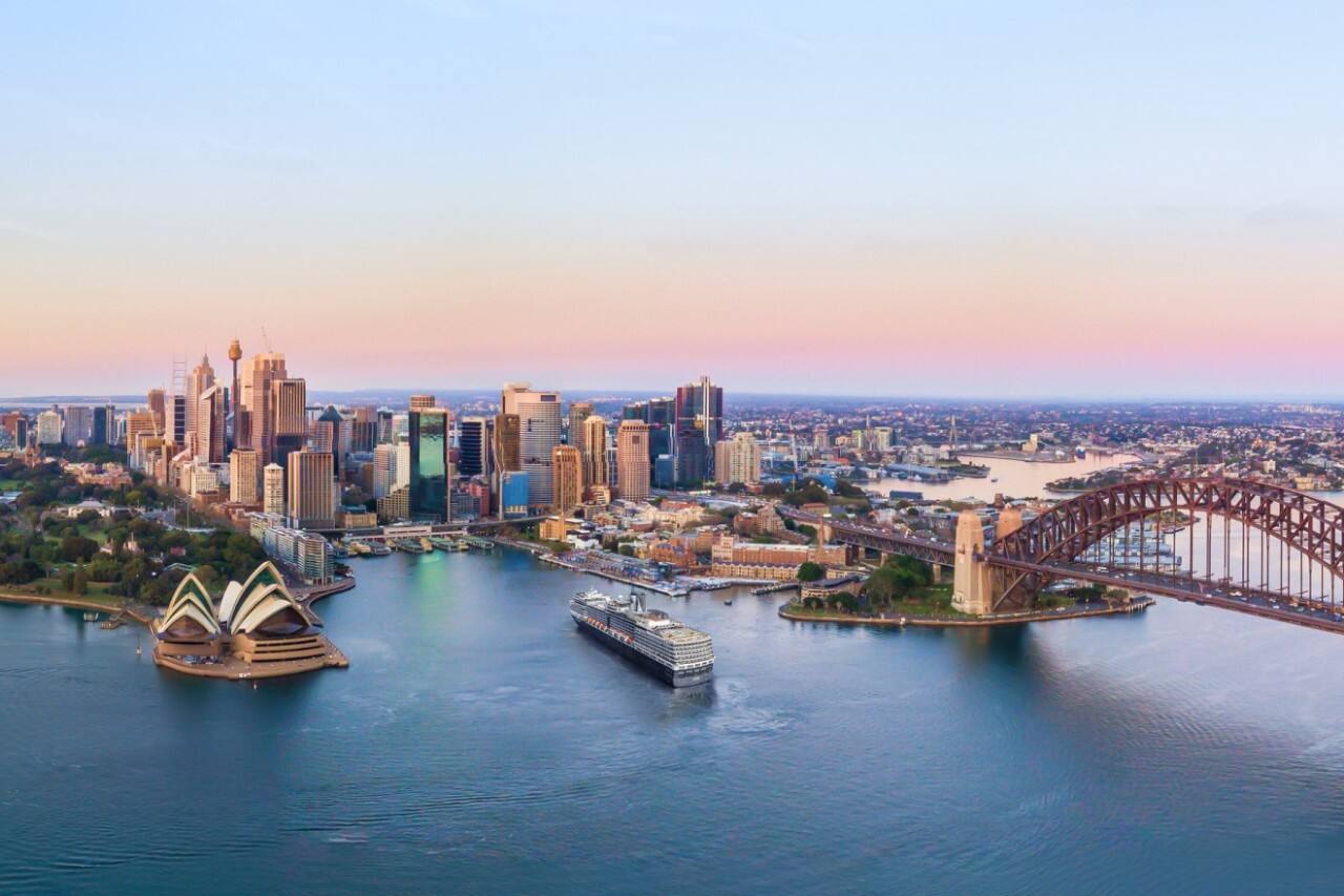 Aerial view of a cruise ship landing near the opera house in Sydney Harbor, Australia.