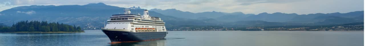 Holland America Line's Volendam cruise ship sailing on smooth waters filled with the sun's reflection.