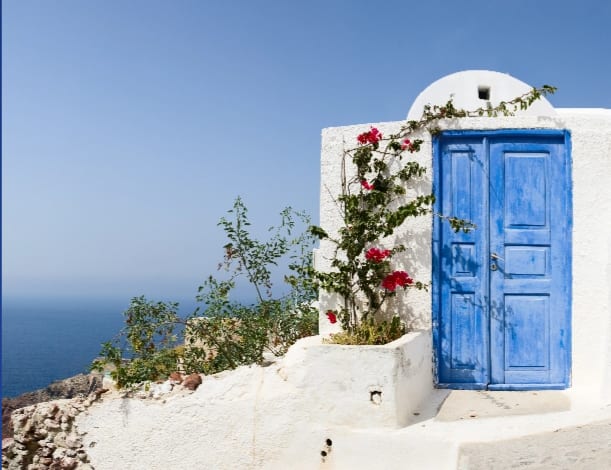 A Blue door marks the entrance to a home in Santorini, Greece.