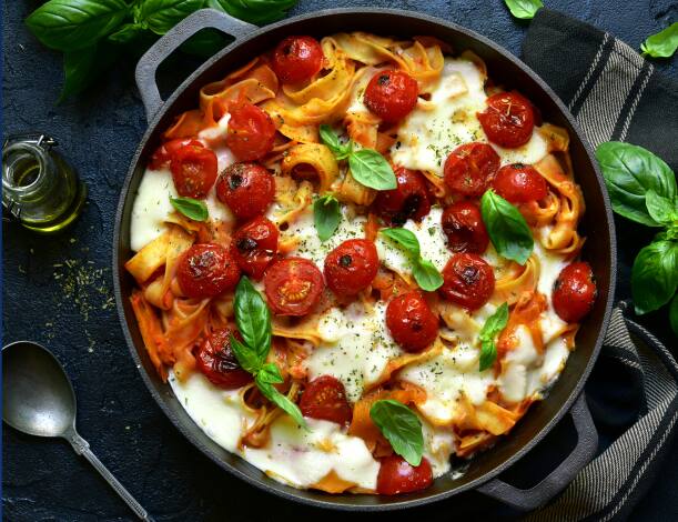 Italian pasta dish with fresh basil and tomatos.