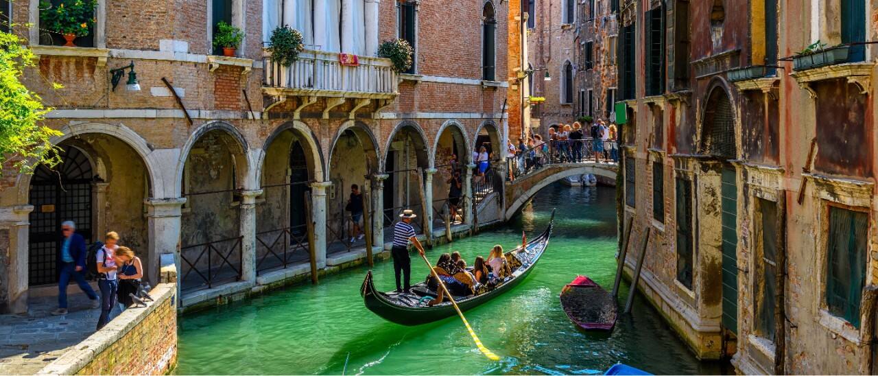 Gondala carries passengers along the Venice Canal in Italy.