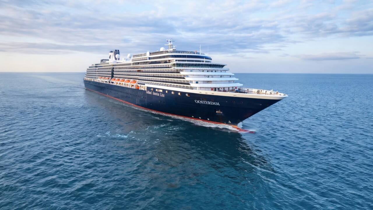 Holland America Line Oosterdam cruise ship sailing through open ocean under a cloudy sky