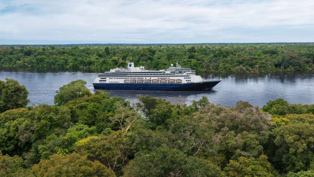 Person stretching in bed inside a Holland America cruise stateroom.