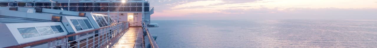 A view of the deck of a ship with the ocean in the background.