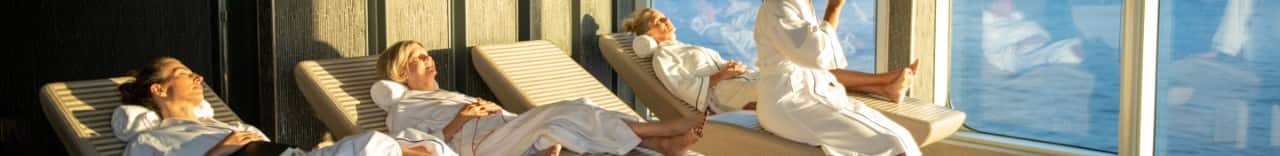 A group of women laying & sitting on lounge chairs in the spa.
