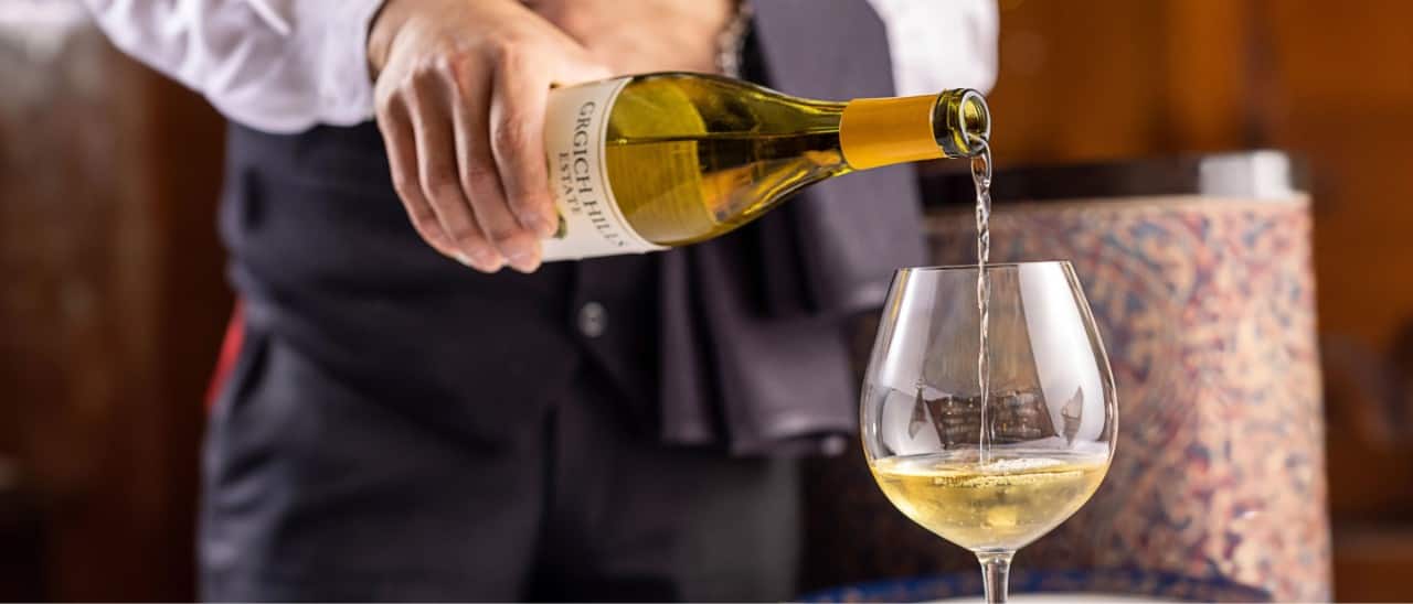 A man pouring wine into a wine glass.