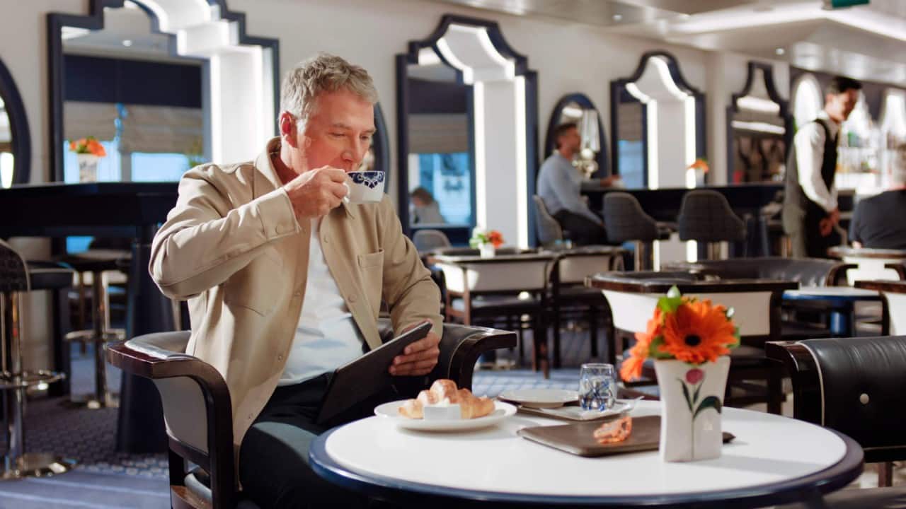 Guest seated inside the Grand Dutch Café onboard.