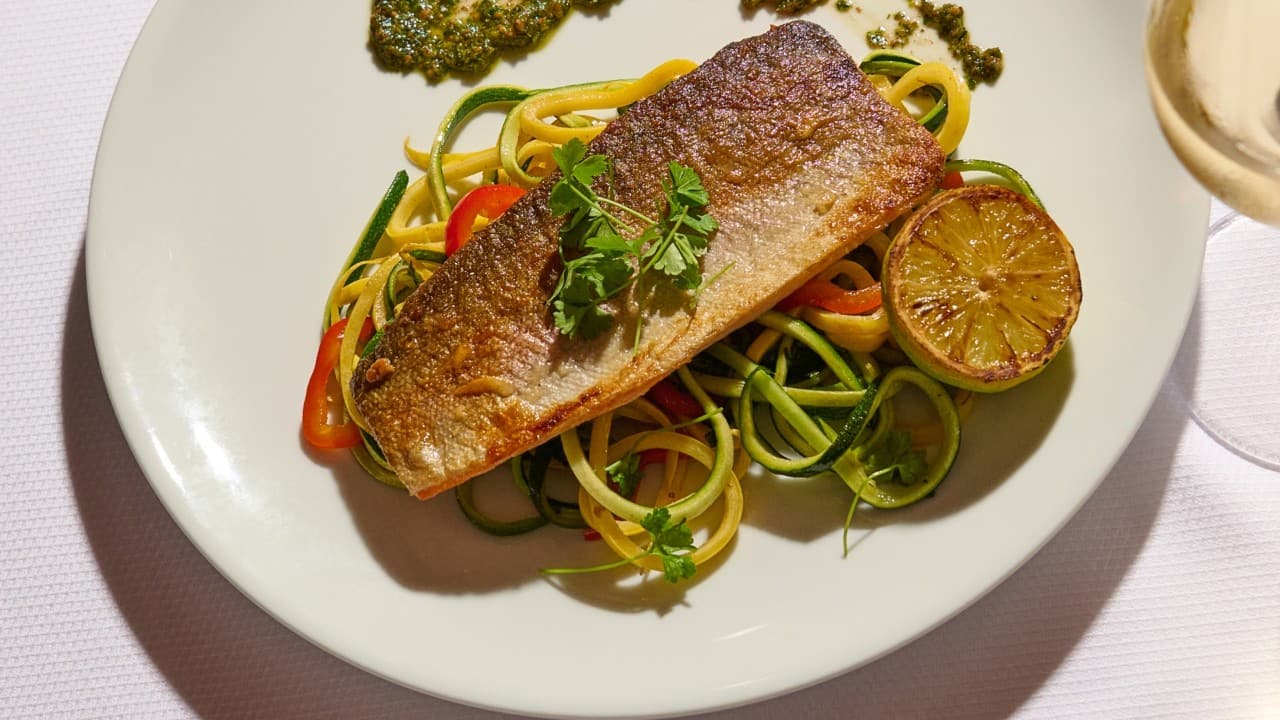 Seared fish fillet on spiralized zucchini and squash noodles with grilled lime and herb sauce.