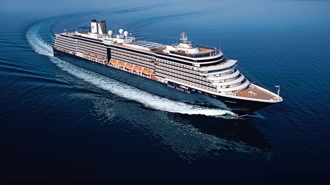 Aerial view of a Holland America ship sailing through deep blue ocean.
