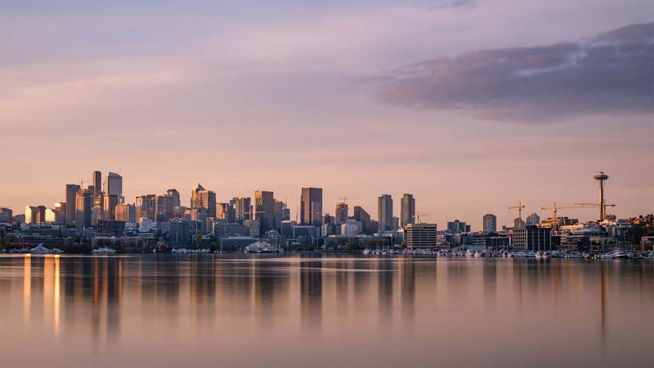 Morning light falls over Lake Union and the Seattle skyline with reflection